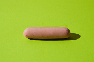Sausage on a bright green background with hard light