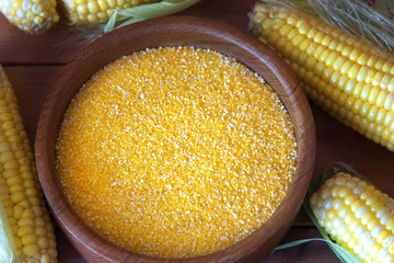 Corn groats on wooden rustic background. Polenta