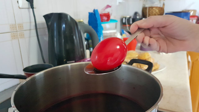 red easter eggs  while painting and polishing in the kitchen