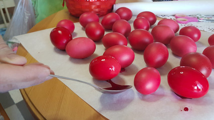 red easter eggs  while painting and polishing in the kitchen