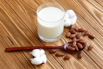 Vegetable vegetarian milk, almond nut milk on a wooden background
