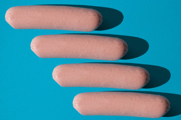 Pattern, a lot of raw sausages on a blue background