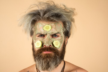 Close-up portrait of morning man applying facial mask. Spa concept. Man with facial mask in beauty salon, close up. Portrait of man with clay facial mask.
