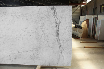 Obraz premium A slab of natural white marble with gray veins in a stone warehouse is called Bianco Gioia