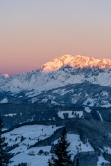 Obraz premium A snowy early morning view from a mountain top in Wagrain in Salzburg in Austria towards the Hochkönig mountain range