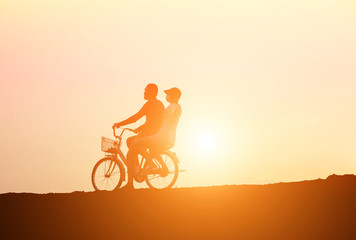 Fototapeta premium silhouette of couple driving bike happy time sunset