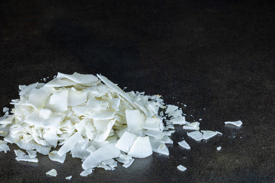 Gros plan sur un tas de chips de noix de coco blanches sur fond noir