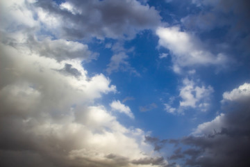 Clouds in the blue sky. A stunning gray sky. The storm is approaching. A beautiful clouds against the blue sky background. Amazing cloud pattern in the sky.