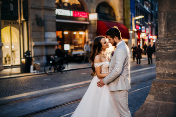 Fototapeta premium Beautiful bride and groom embracing and kissing on their wedding day outdoors