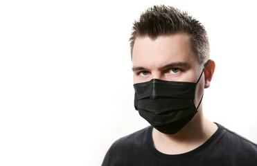 Closeup frowning man in disposable medical mask isolated on a white background. Covid-19 coronavirus epidemic. Quarantine and self-isolation mode to save the population.