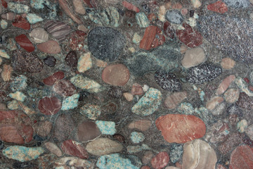 Aquarius granite with a frozen bright pattern of many colorful pebbles