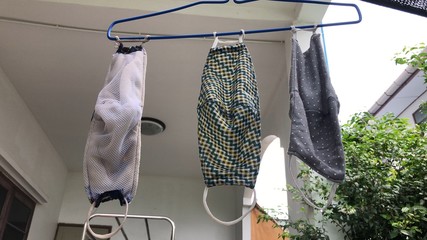 Cotton cloth mask hanging outdoor after the used and washing,natural glare light,the mask repeated...