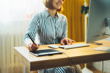 Obraz premium smile woman working at home workplace on computer, student online education with internet technology, social isolation work process, female hands graw on portable tablet at home interior