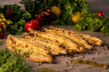 traditional cheese pita with vegetables on wooden background