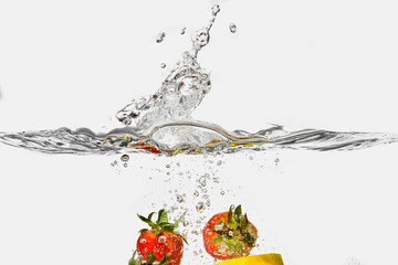 ripe fruits splashing in transparent water