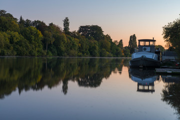 Obraz premium petit bateau de plaisance au levé du jour sur une rivière en automne à Nantes en France