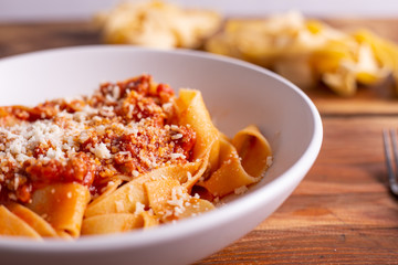 Tagliatelle with Bolognese ragu. Italian traditional tagliatelle dish with tomato and beef sauce. Rustic food, lunch with family.