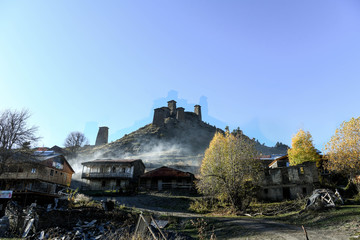 Obraz premium Stary fort wychodzi na wioskę górnego Omalo, tonącą w dymie z komina