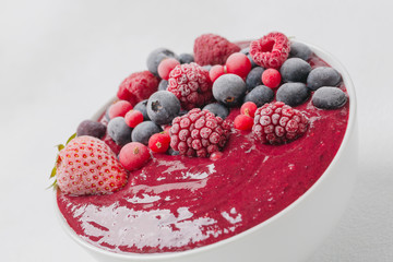 Healthy smoothie bowl with frozen berries. Smoothie with strawberries, blueberries, blackberries, raspberries and red currants. Close up 