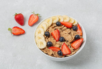 Multigrain wholegrain healthy cereal with banana and fresh berries strawberries and blueberries for Breakfast. Concept of delicious and healthy food.