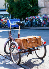 Fototapeta na wymiar An old tricycle / bike with a straw basket on a street in Cambridge