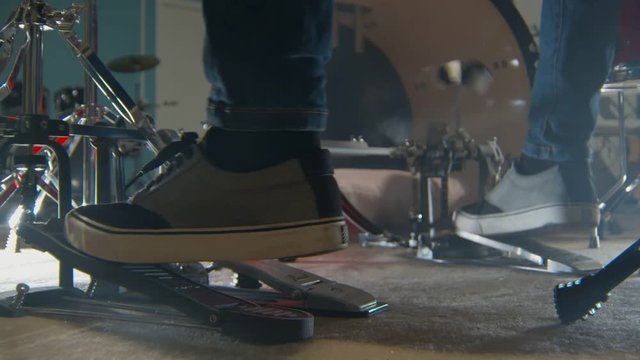 feet of drummer are pressing pedal of bass drums, playing music, closeup