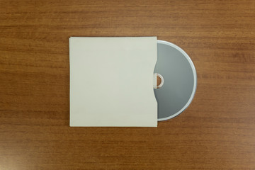 Empty grey CD and CD case in a wood background for mockup purposes