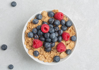 Multigrain wholewheat healthy cereals with fresh berry for breakfast. Bowl flakes with fresh berries raspberries and blueberries. 