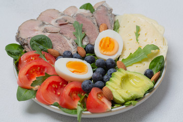 Ketogenic diet. Bowl with meat, avocado, eggs, berries, tomatoes, cheese and nuts. Detox and healthy concept. Keto food. 