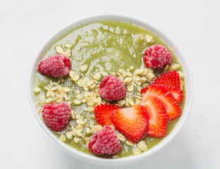 Breakfast green smoothie bowl with kiwi, banana, spinach, grapes, strawberries, raspberries and oatmeal. The concept of a detox diet.