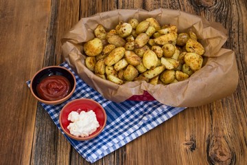 .baked potatoes with ketchup and mayonnaise on wooden background . food concept