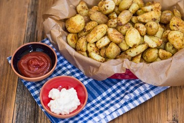 .baked potatoes with ketchup and mayonnaise on wooden background . food concept