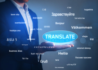 Online Translator, hand holding button Translate over greeting words in different foreign languages.Business and technology concept. .
