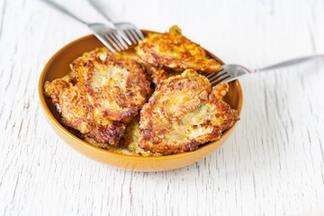 Turkey fillet in batter in a ceramic bowl, 3 forks on the edge of the plate