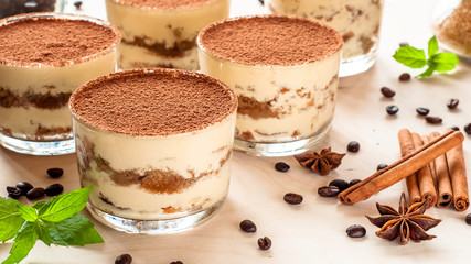 Tiramisu in the glass decorated whith mint on the wooden background