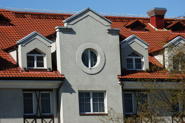 red roof of an old building with a round window in the attic
