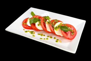 Traditional Italian Caprese salad on the plate on black background