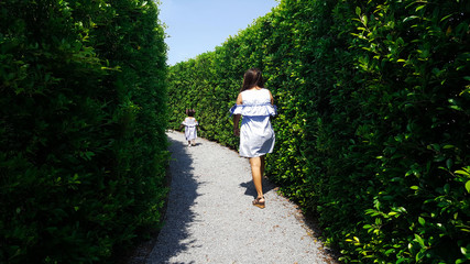 Fototapeta na wymiar child and mom escape maze green plant wall
