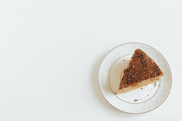 A slice of brown cake on a white saucer