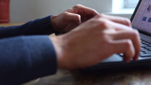 men's hands work on the keyboard of the laptop