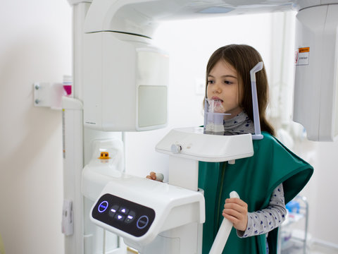 medicine, dentistry and healthcare concept.   x-ray machine scanning  kid patient teeth at dental clinic 