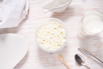 White cottage cheese in plastic jar on wooden table