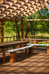 Wooden gazebo in nature in the Park for events. Sunlight through a grid of wooden beams-a game of chiaroscuro. Place for text and background