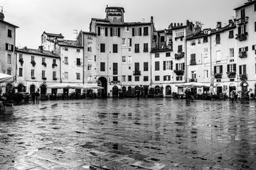 Black and white image of the Piazza dell'Anfiteatro in Lucca, an elliptical shape square built on the ruins of a Roman Amphitheater, Tuscany, Italy