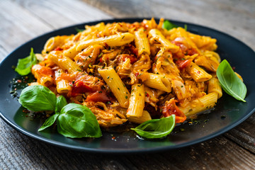 Chicken ragout with penne on wooden table