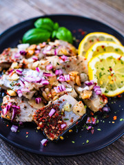 Marinated herrings with lemon and onion on wooden table
