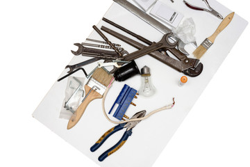 Mess of construction tools, drill, spanner, pliers, wire cutters, brush, lappochka on a white background. 
Dirty workshop table with old metal rusty work tools