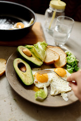 Healthy breakfast: scrambled eggs, toast, avocado, lettuce, rosemary

