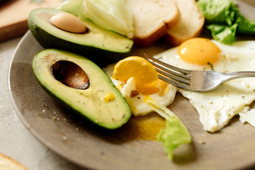 Healthy breakfast: scrambled eggs, toast, avocado, lettuce, rosemary
