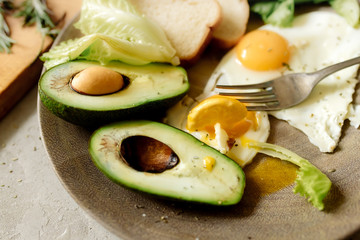 Healthy breakfast: scrambled eggs, toast, avocado, lettuce, rosemary
